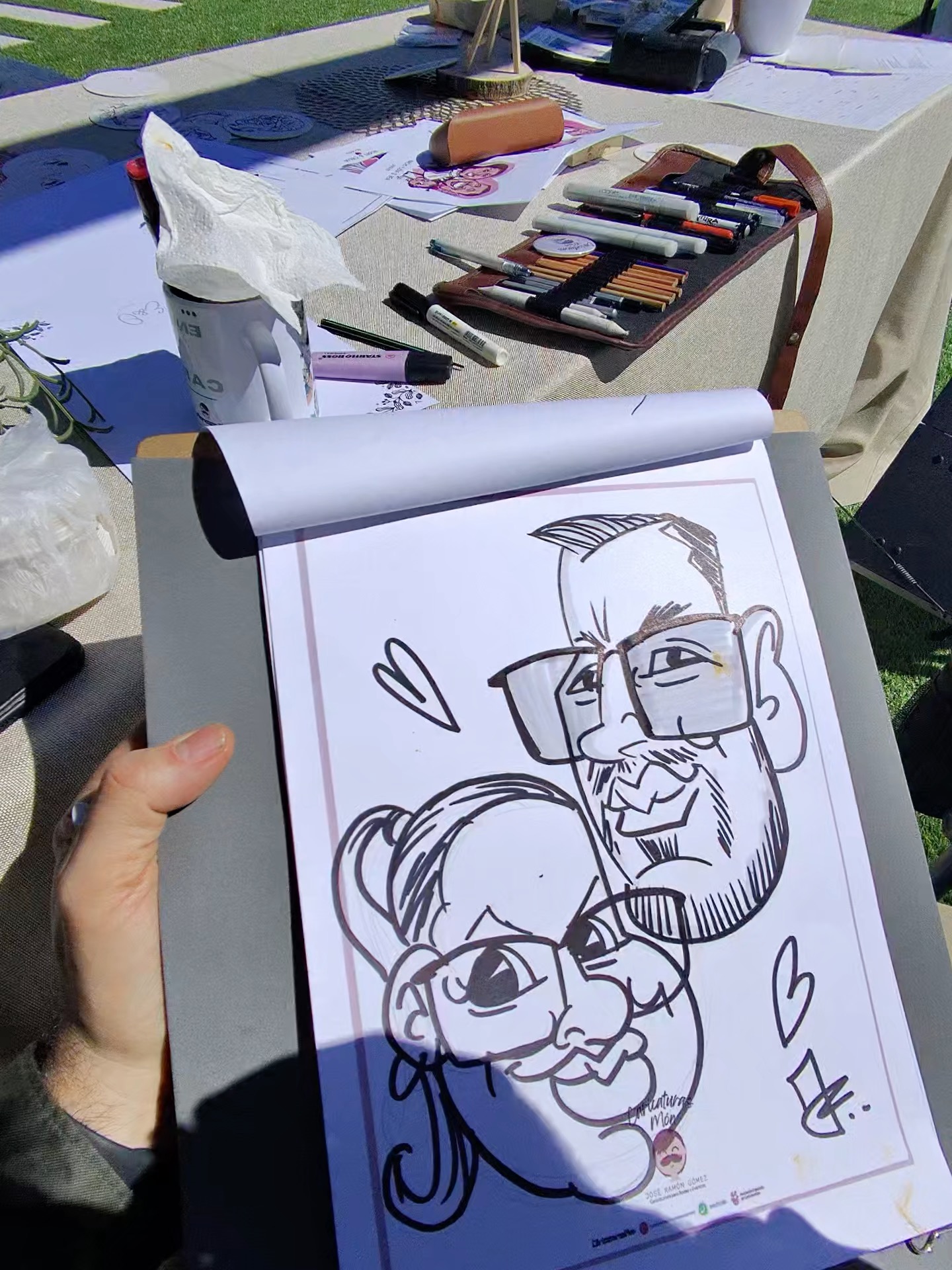 Caricatura de una pareja dibujada en vivo durante una boda al aire libre