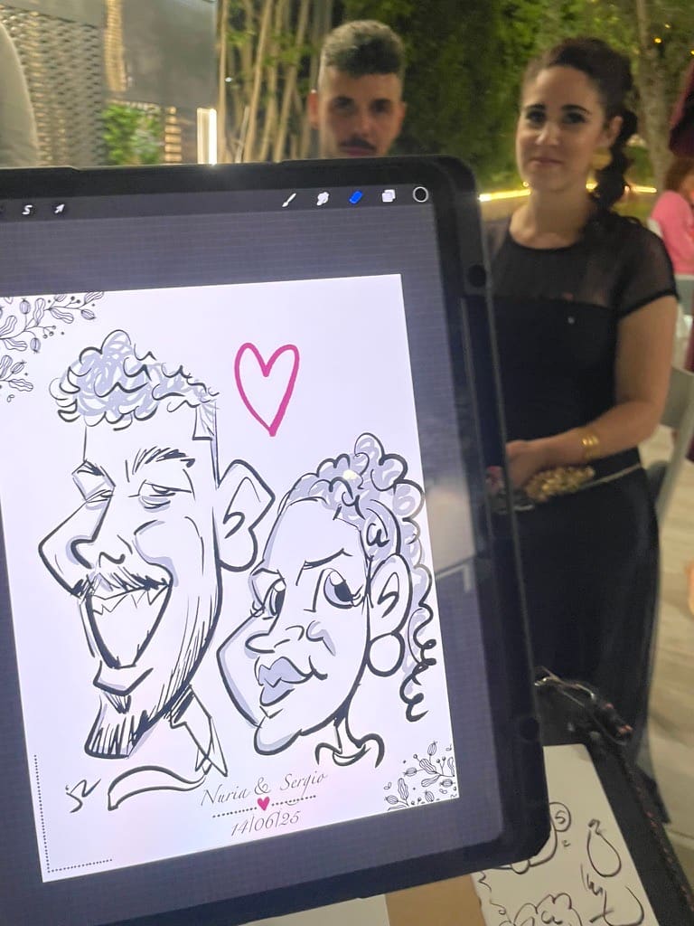 Pareja posando mientras se muestra su caricatura digital en directo